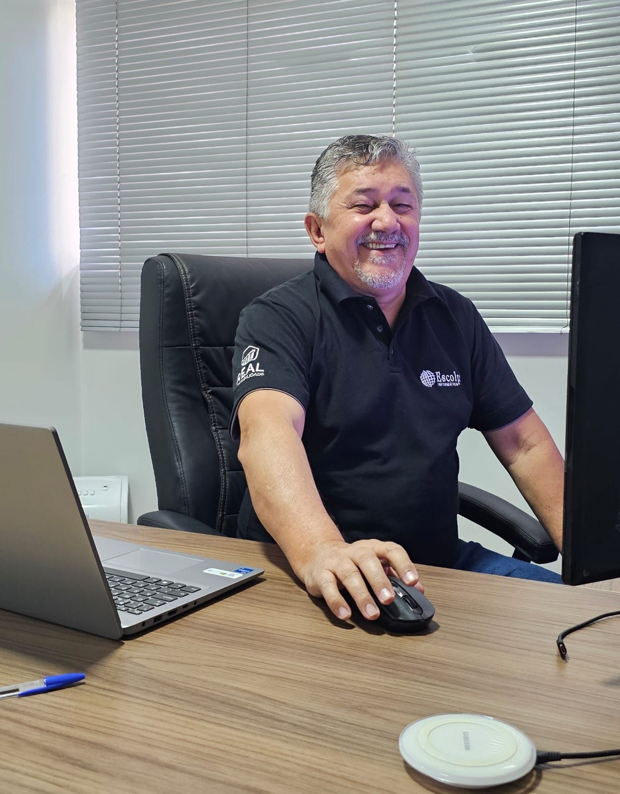 Contador da Real Contabilidade BH sorrindo em sua mesa de trabalho